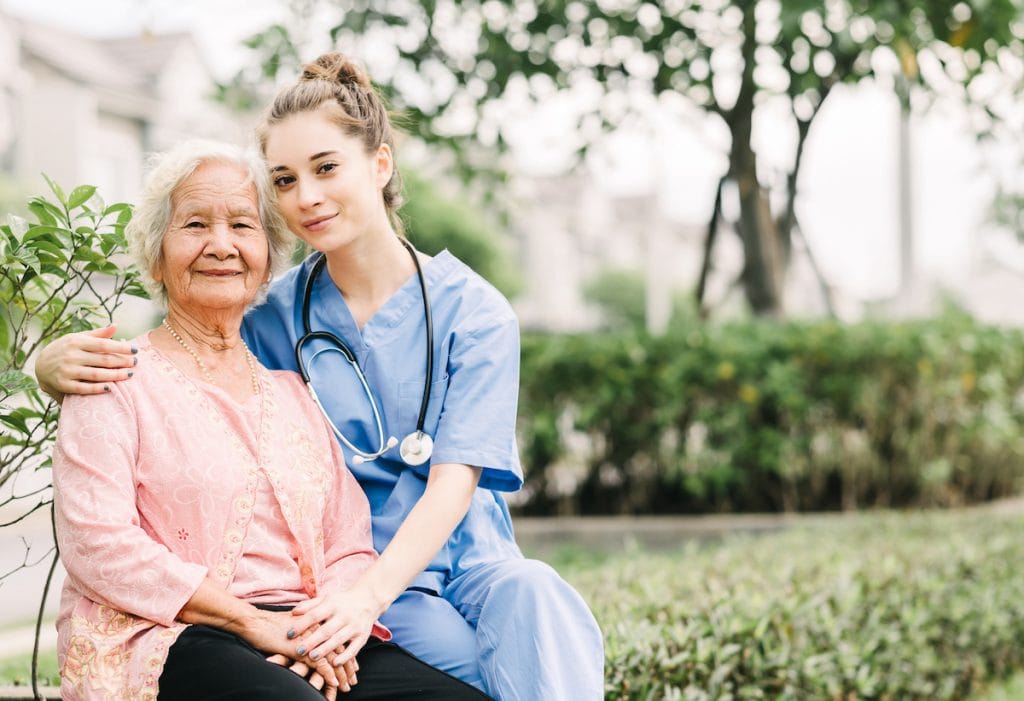Caregiver and senior resident outdoors