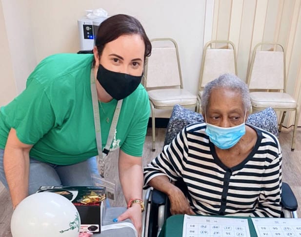Staff member assisting a resident during an activity.