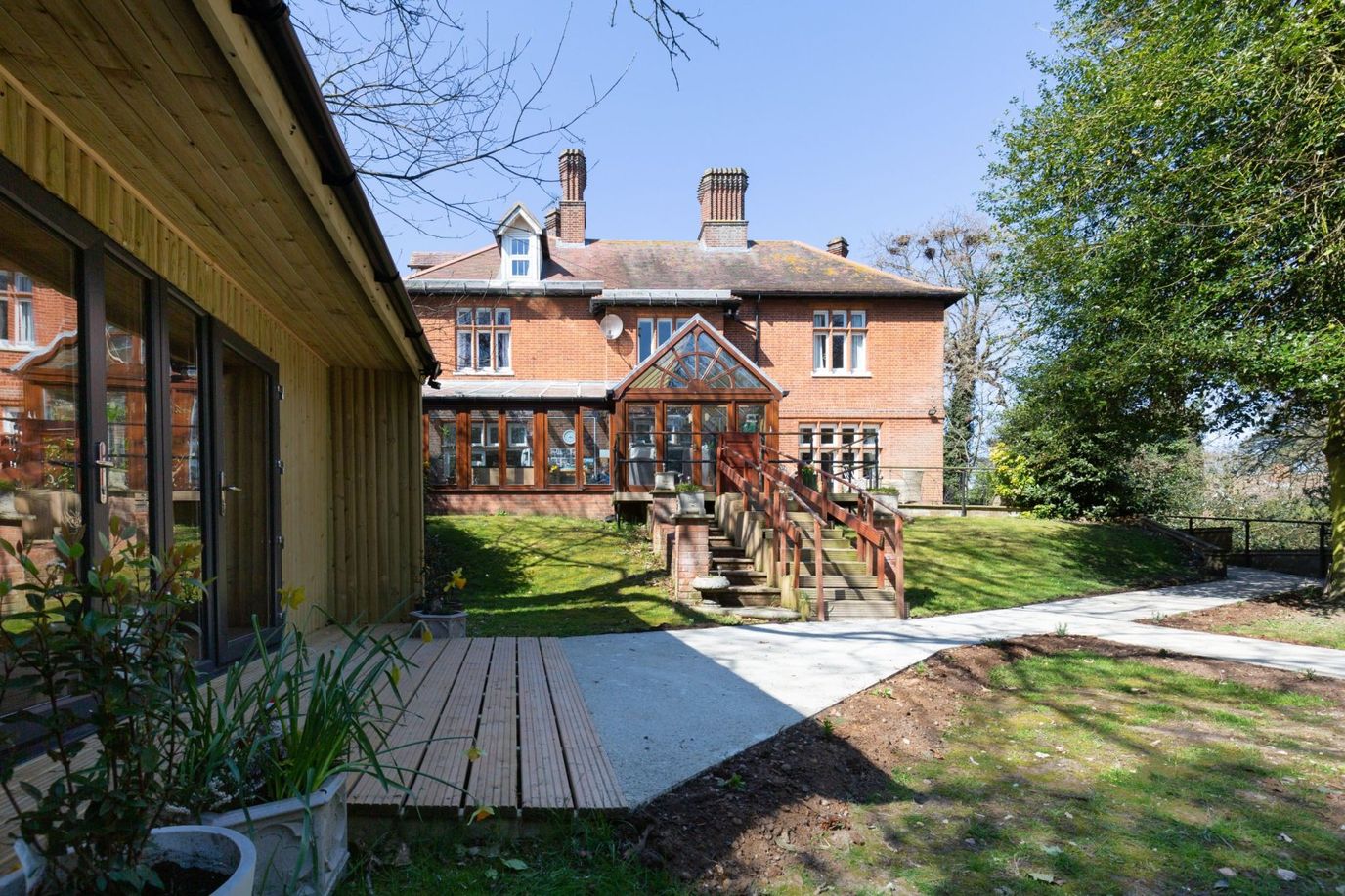 Exterior view of a care facility with gardens and patio.