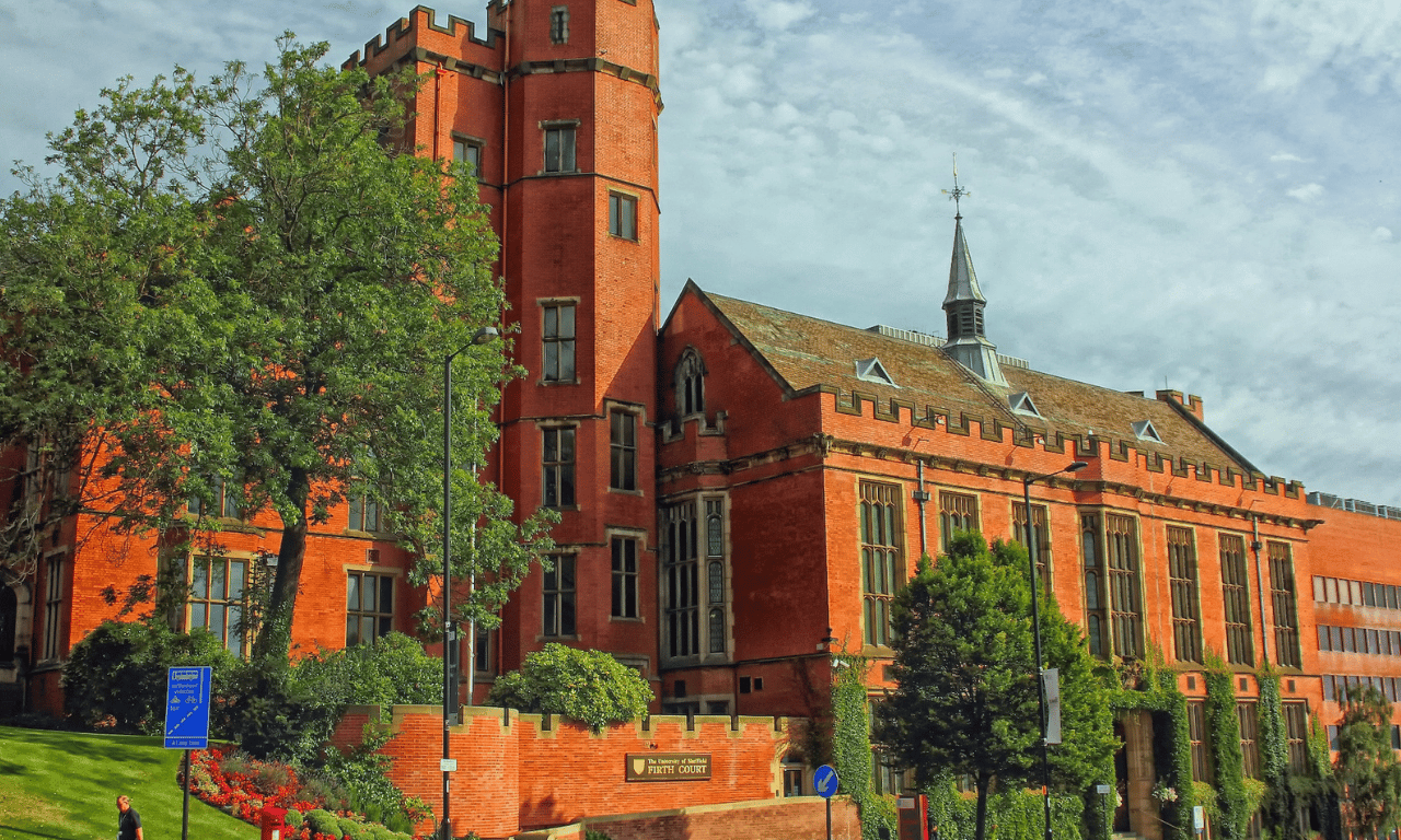 Exterior view of a red brick building with gardens.