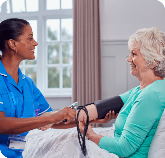Nurse taking blood pressure of a smiling resident