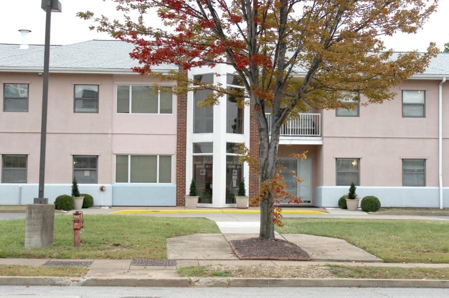 Exterior view of a senior living facility with trees