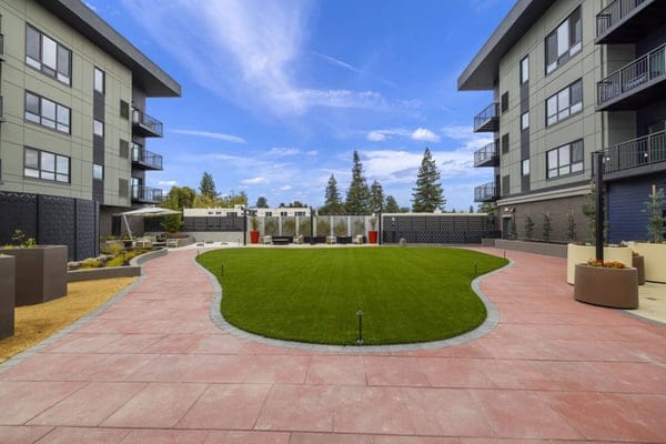 Outdoor courtyard area with grassy lawn and seating
