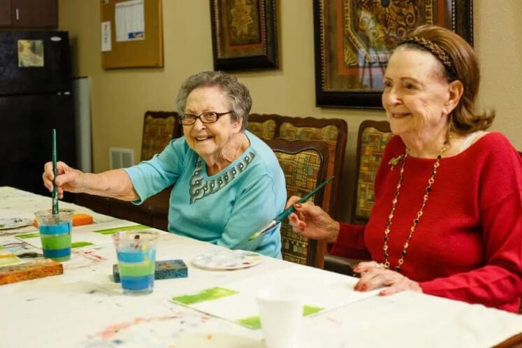 Two residents enjoying a painting activity