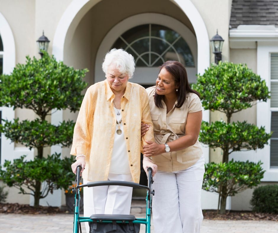A caregiver assisting a senior resident outdoors