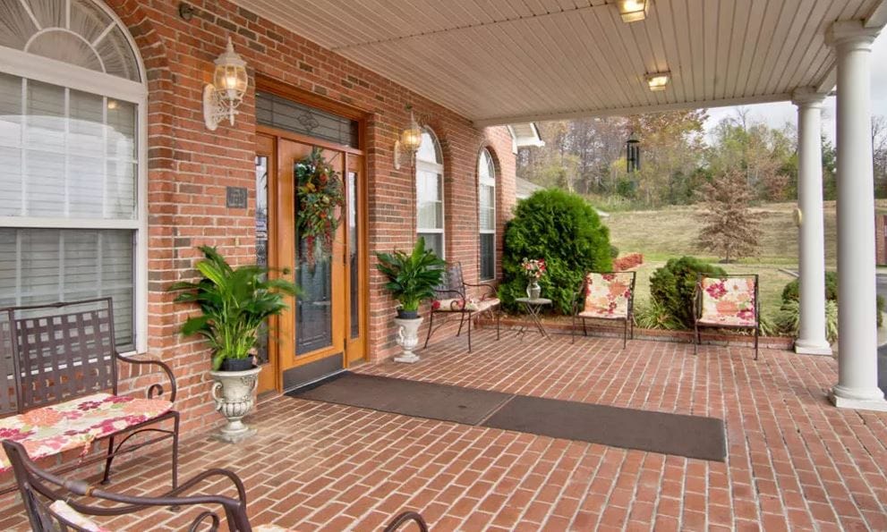 Front entrance of a welcoming assisted living facility with seating area