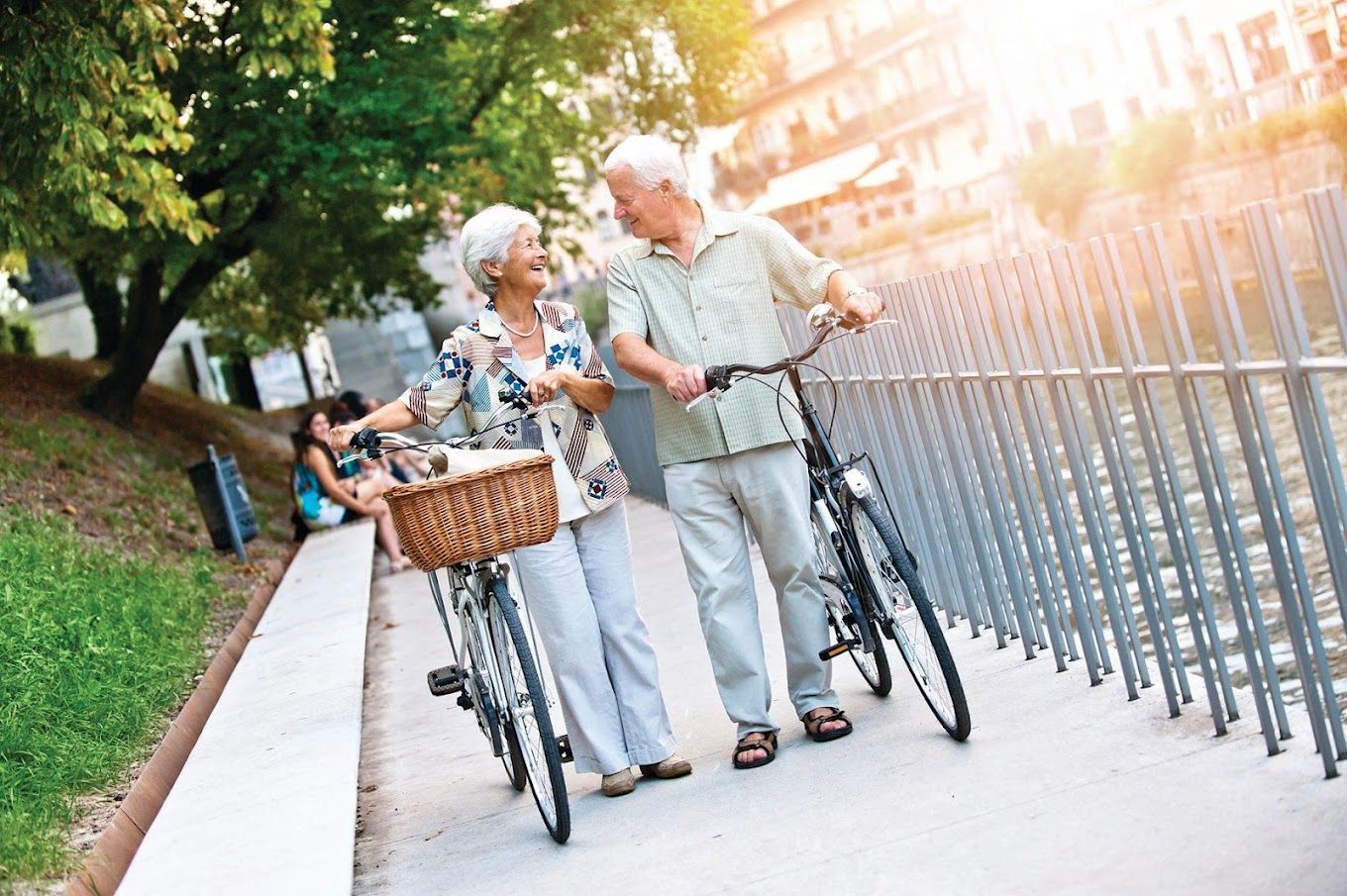Older couple enjoying a stroll by the water with bicycles