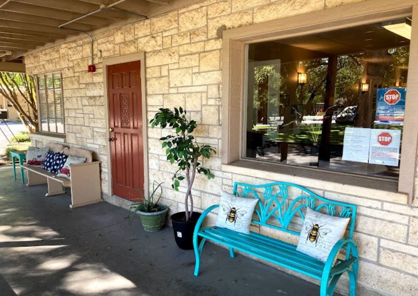 Outdoor seating area with teal bench and potted plants