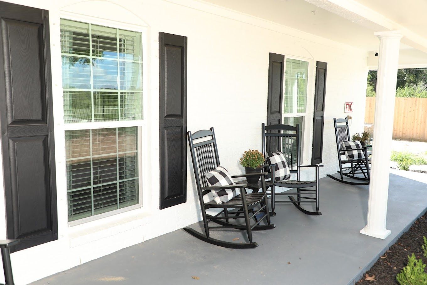 Rocking chairs on a porch with a white exterior
