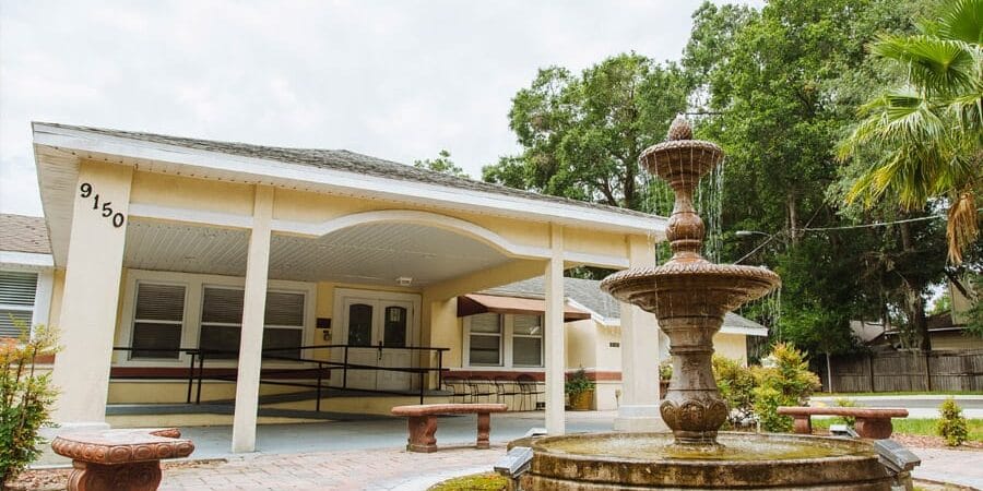 Exterior view of the facility with a fountain and seating