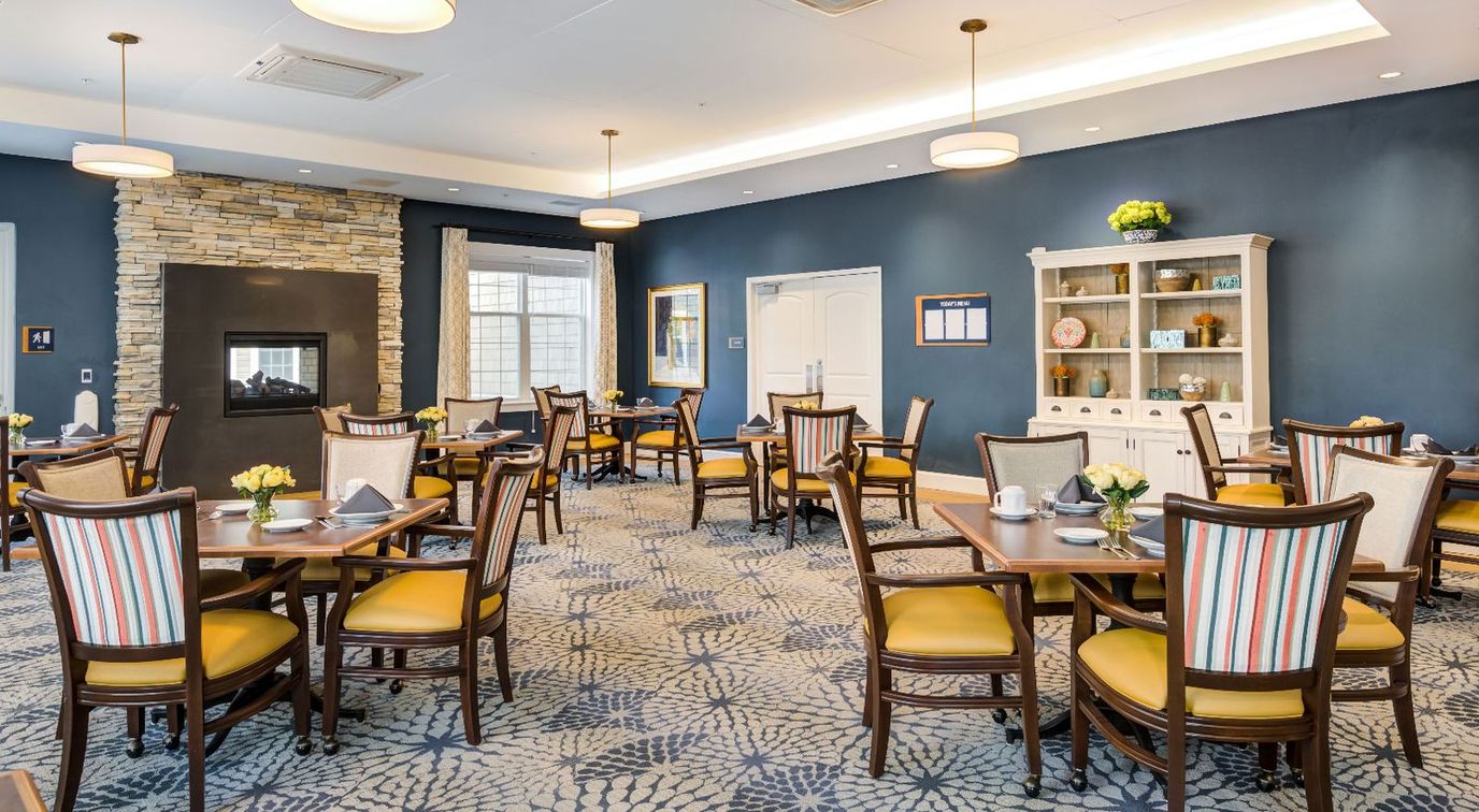 Bright dining area with tables and chairs set for residents