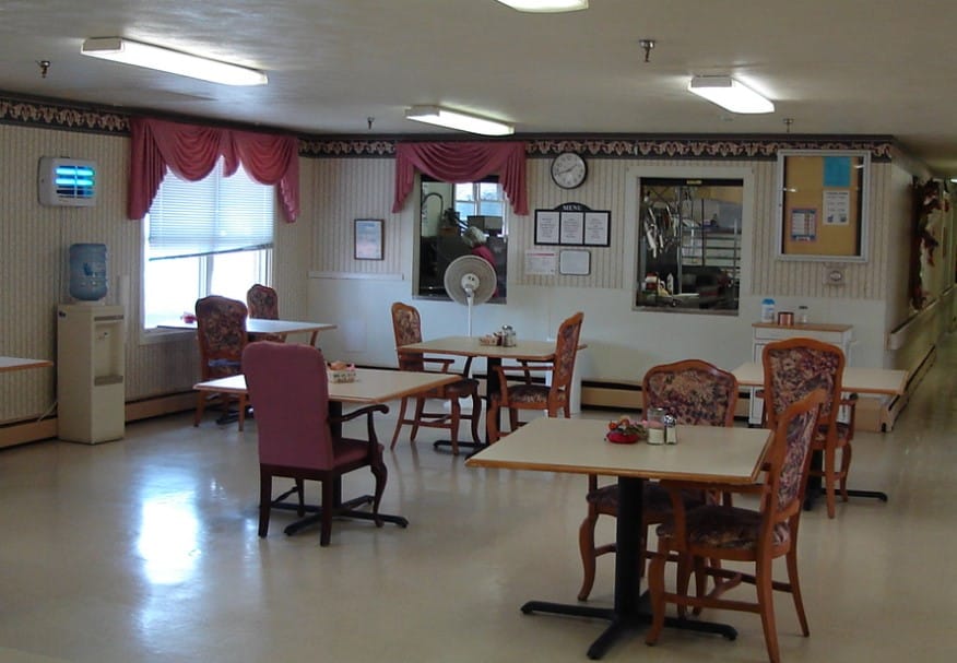 Bright dining area with tables and chairs in a senior living facility