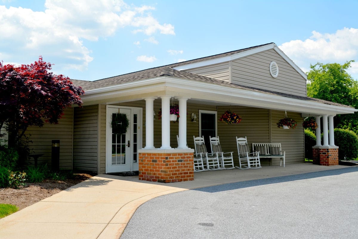 Exterior view of Celebration Villa with rocking chairs and flowers