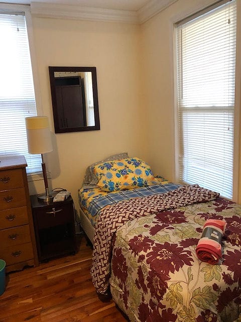 Cozy resident room with floral bedding and natural light