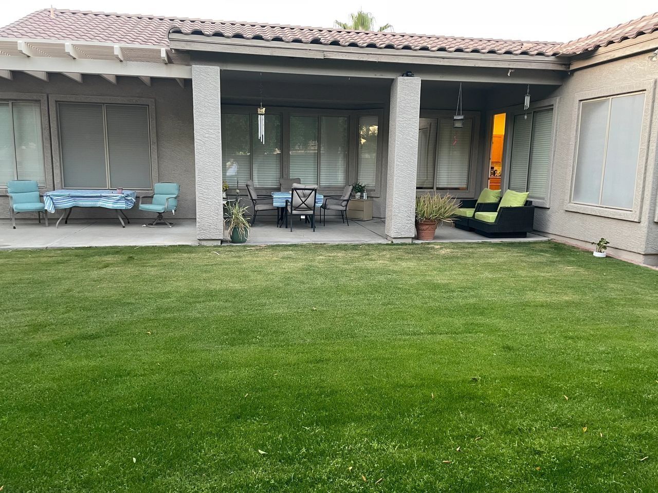 Outdoor patio area with green lawn and seating