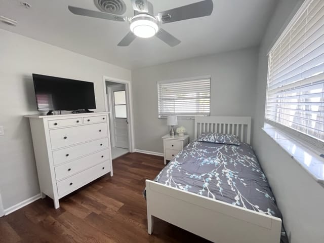 Brightly lit private room with a bed and dresser
