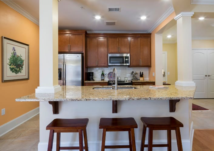 Interior kitchen area with wooden cabinets and bar stools