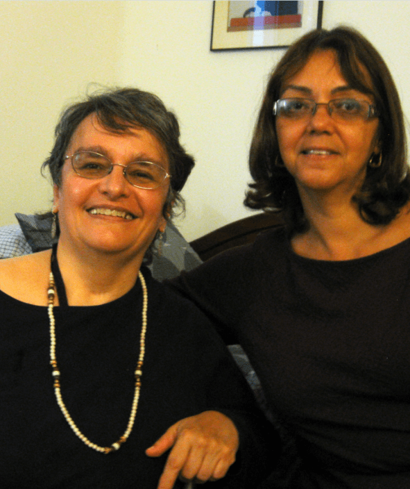Two women smiling in a cozy indoor setting.