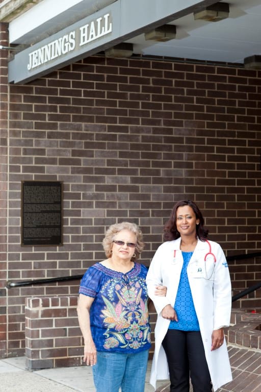 A staff member with a resident at Jennings Hall's entrance
