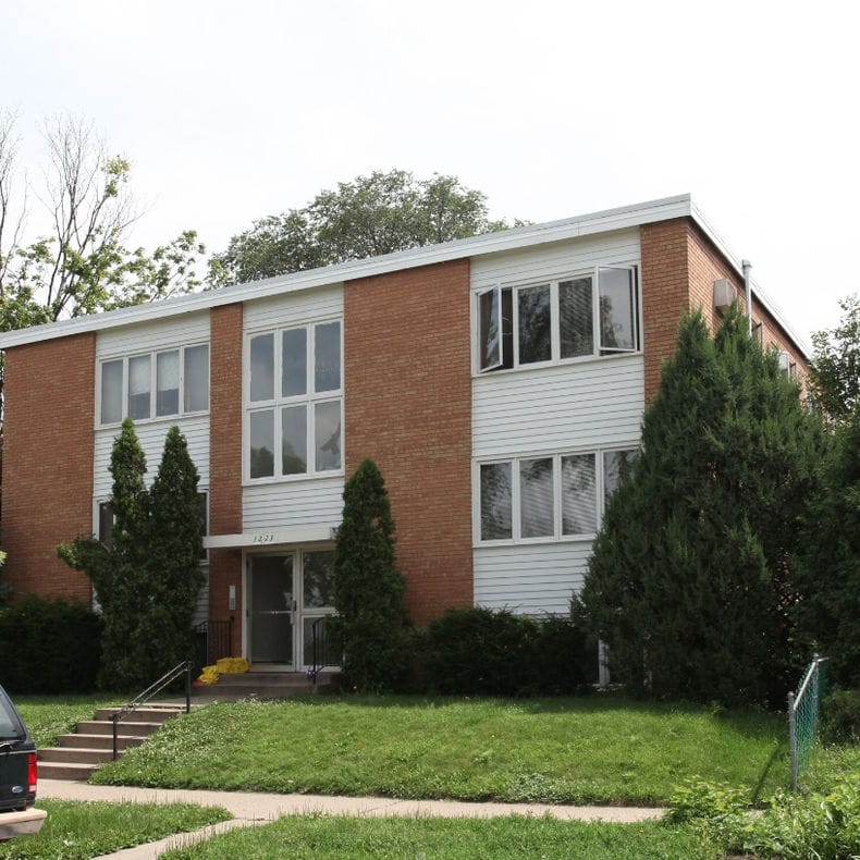 Exterior view of a residential building with landscaping.
