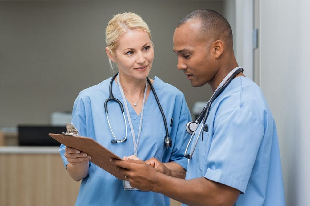 Two healthcare professionals discussing a patient's chart.