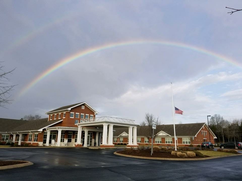 Building exterior with a rainbow in the background.