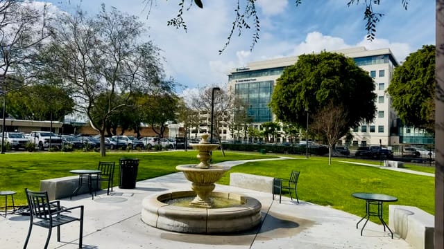 Outdoor space with fountain and building in background