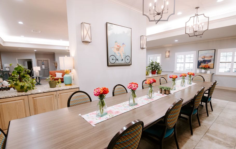 Bright dining area with floral centerpieces and artwork