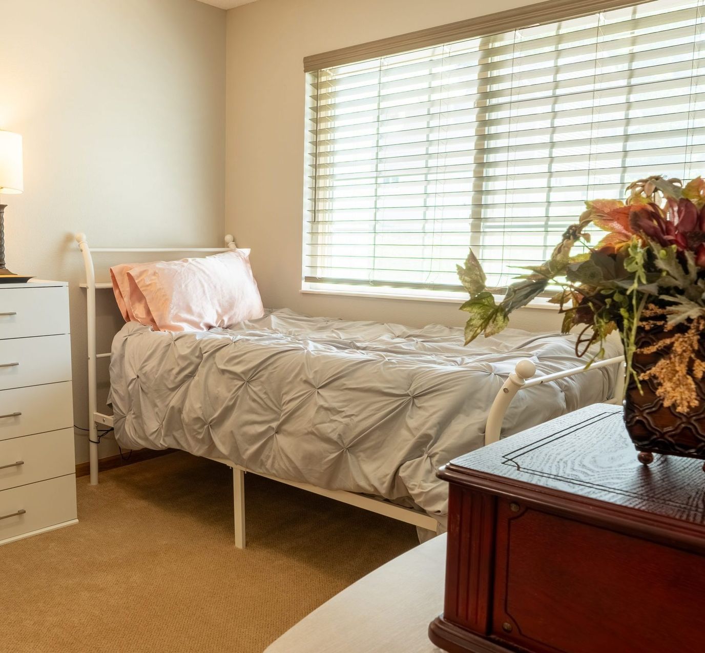 Cozy interior of a resident's room with a bed and decorative plant