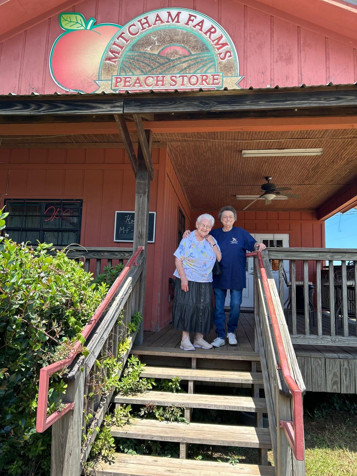 Two residents at the entrance of a peach store