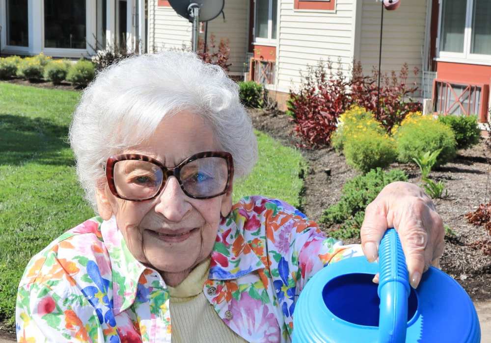 Senior resident watering plants in a garden