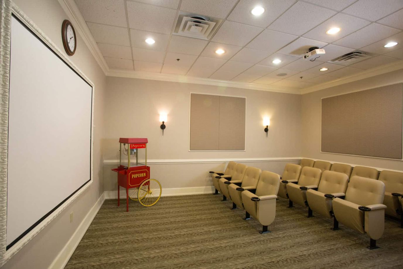 A cozy movie room with seating and popcorn cart