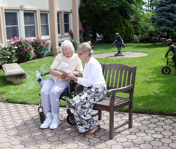 Two residents enjoying time outside in a garden area