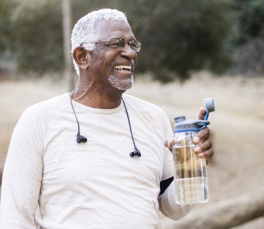 Smiling man holding a water bottle outdoors