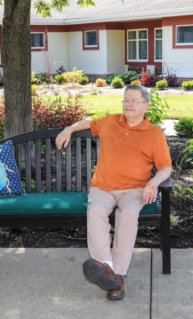 Senior resident enjoying the garden on a bench