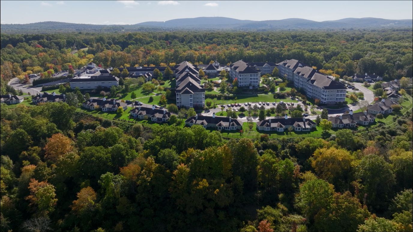 Aerial view of a large senior living campus with colorful trees