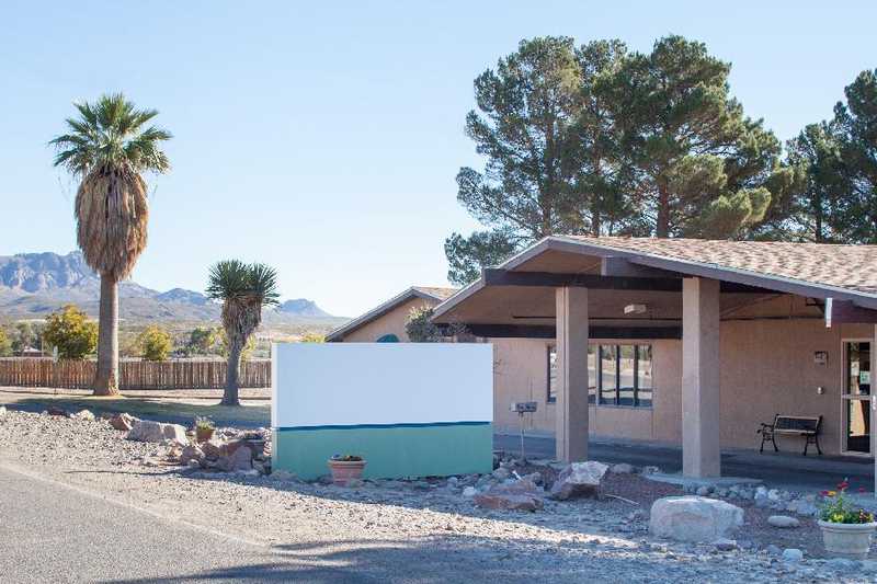 Exterior view of a senior living facility with palm trees