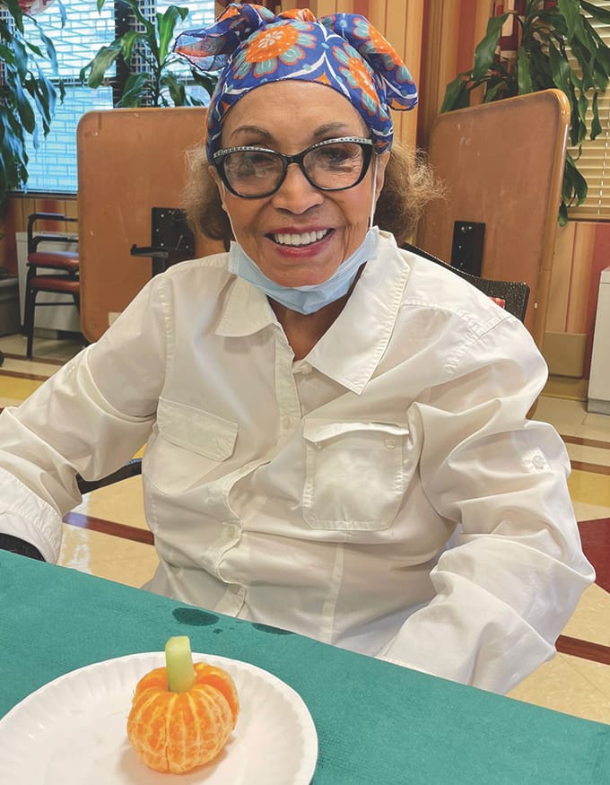 Resident creating a decorative food item during an activity