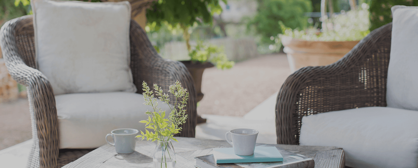 Outdoor seating area with plants and coffee cups