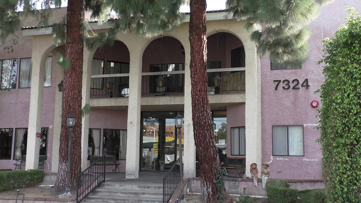 Front exterior of Ambassador Garden facility with trees