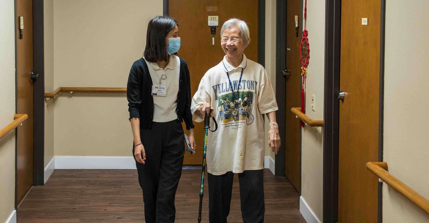 Staff assisting a resident in the hallway