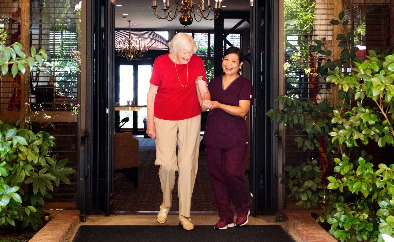 Staff assisting a resident at the facility entrance