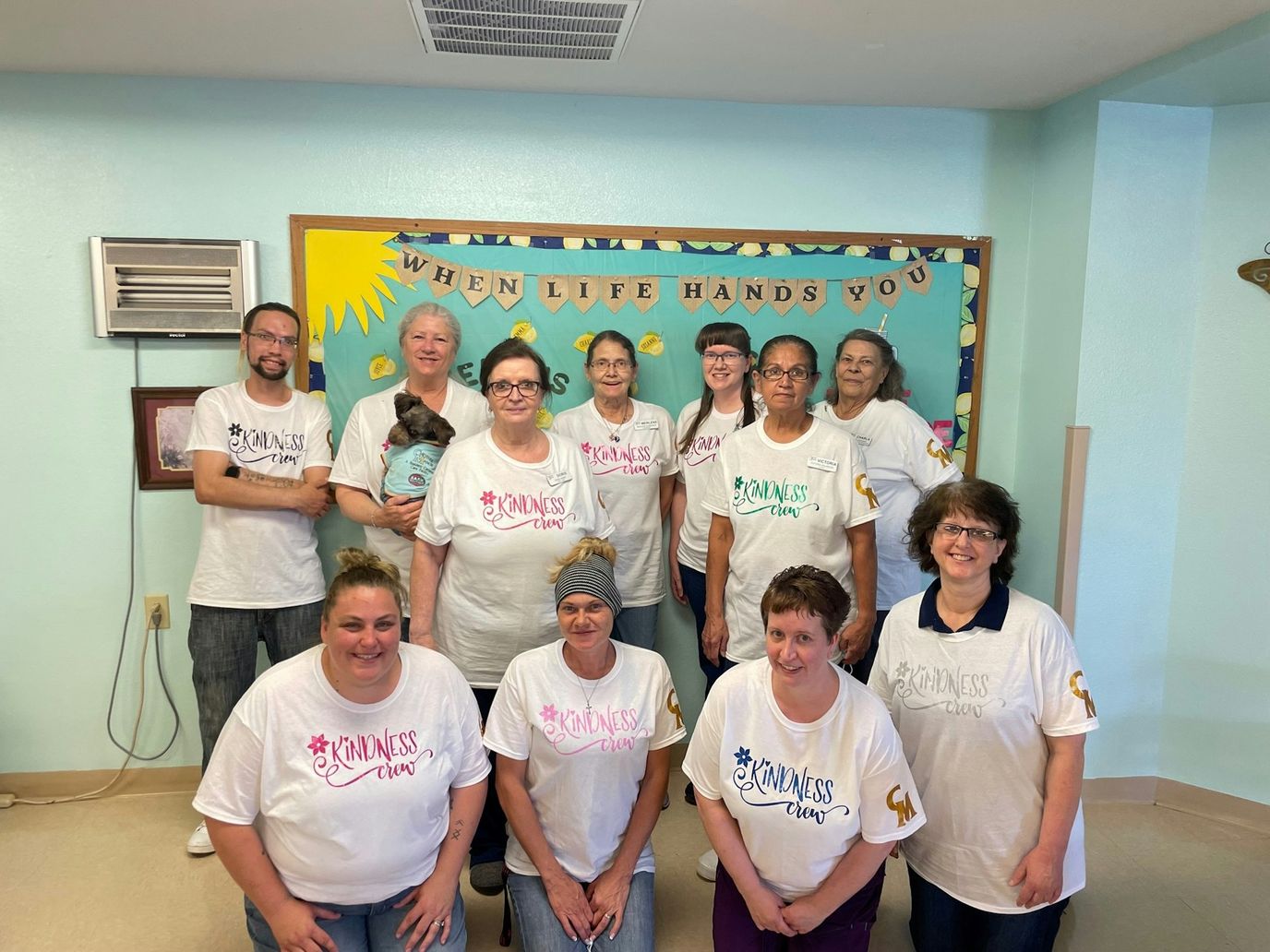 Staff members posing together in a common area