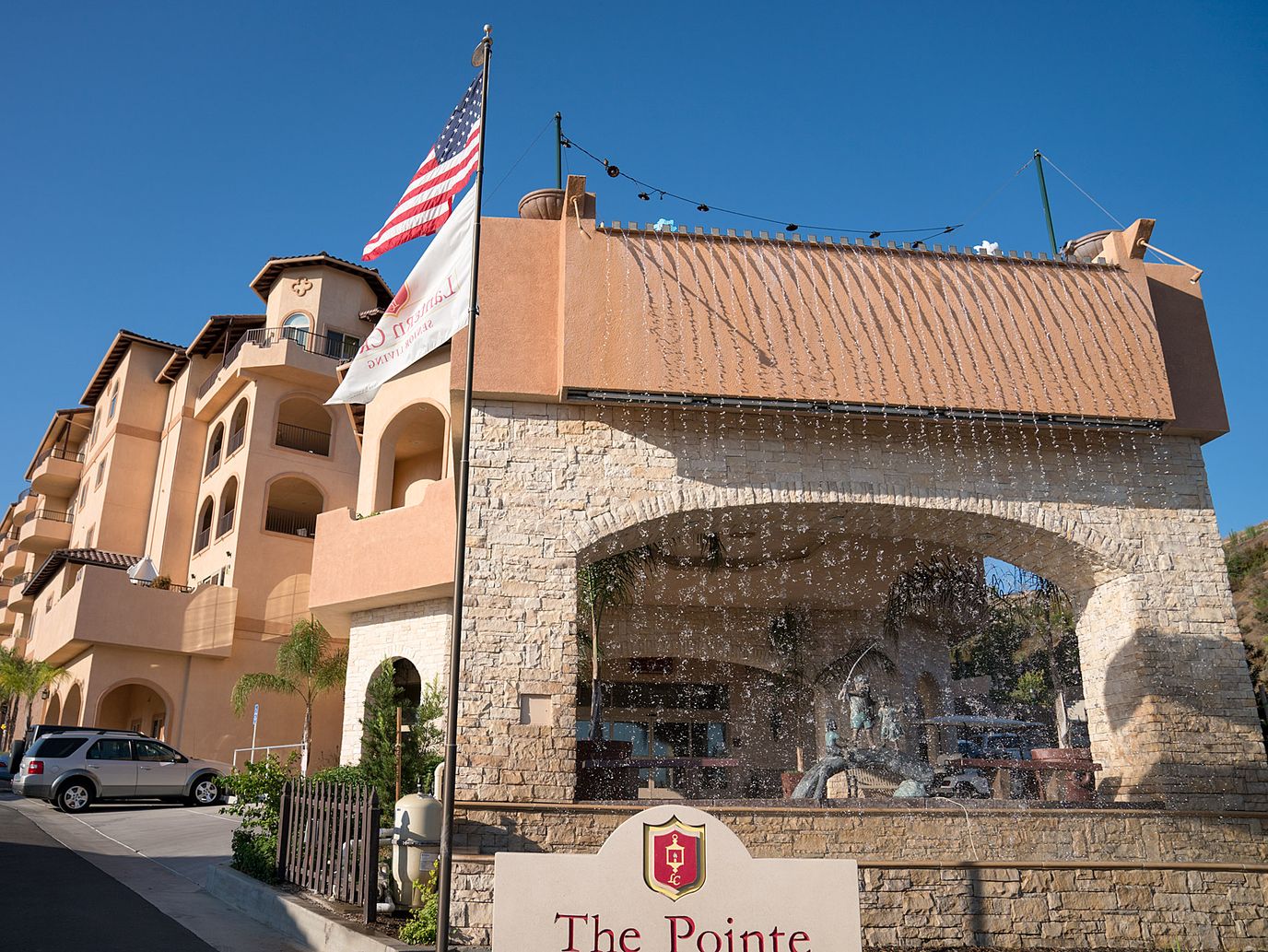 Exterior view of the facility with a fountain and flag