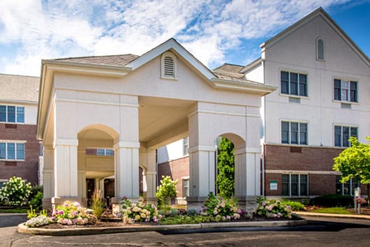 Front entrance of Forest Hills Place with flowers and landscaping