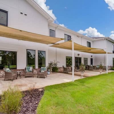 Exterior view of a senior living facility with shaded patio