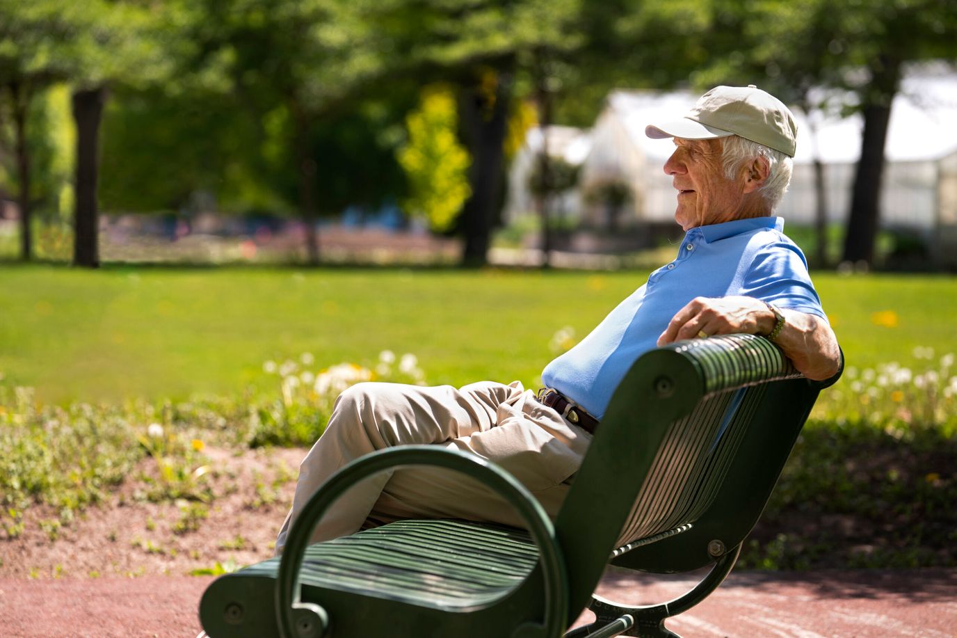 Senior man sitting on a bench in a garden