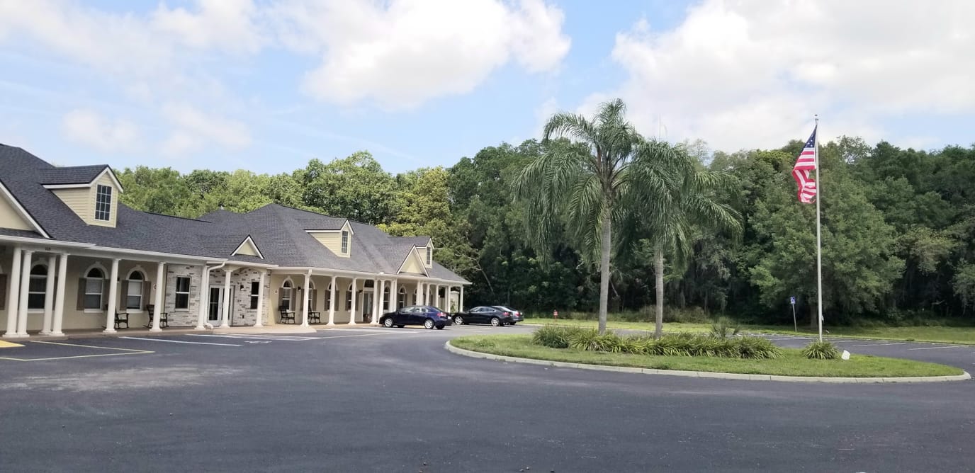 Front exterior of Golden Pond Communities building with a palm tree