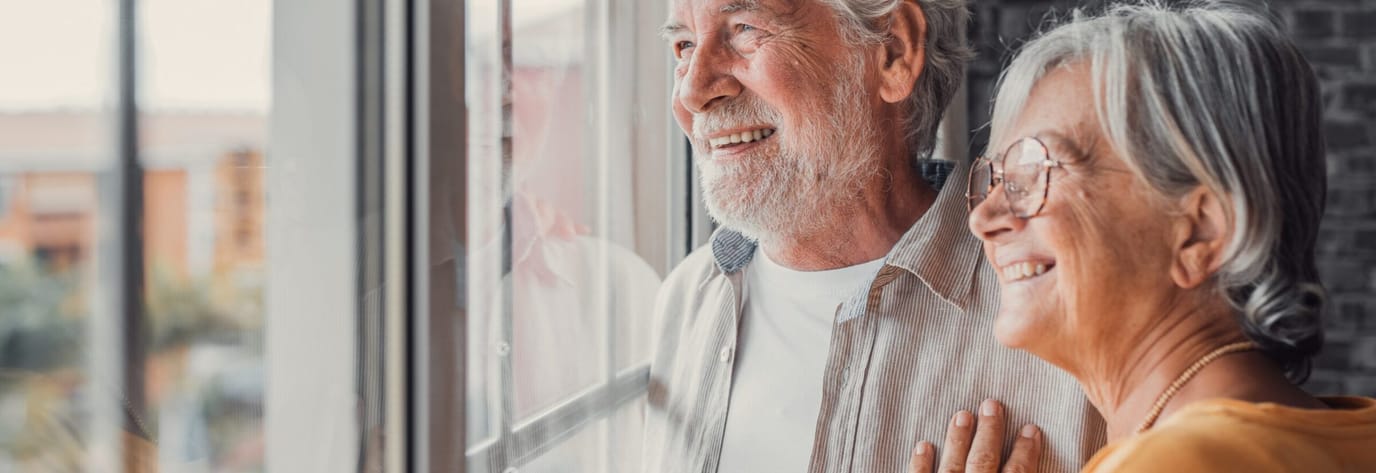 A happy couple looking out a window together