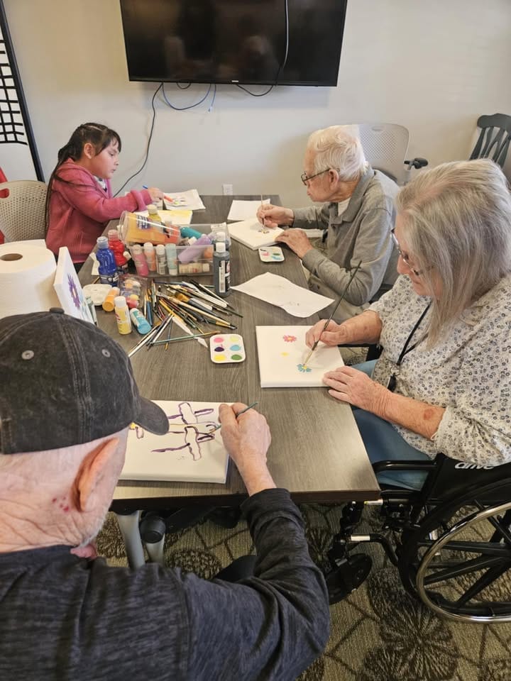 Residents engaging in art activity at a table